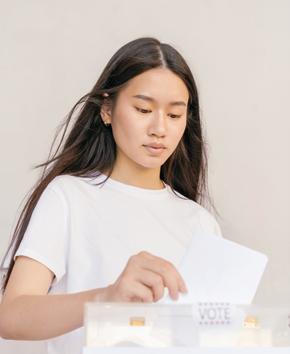 Femme déposant un bulletin de vote