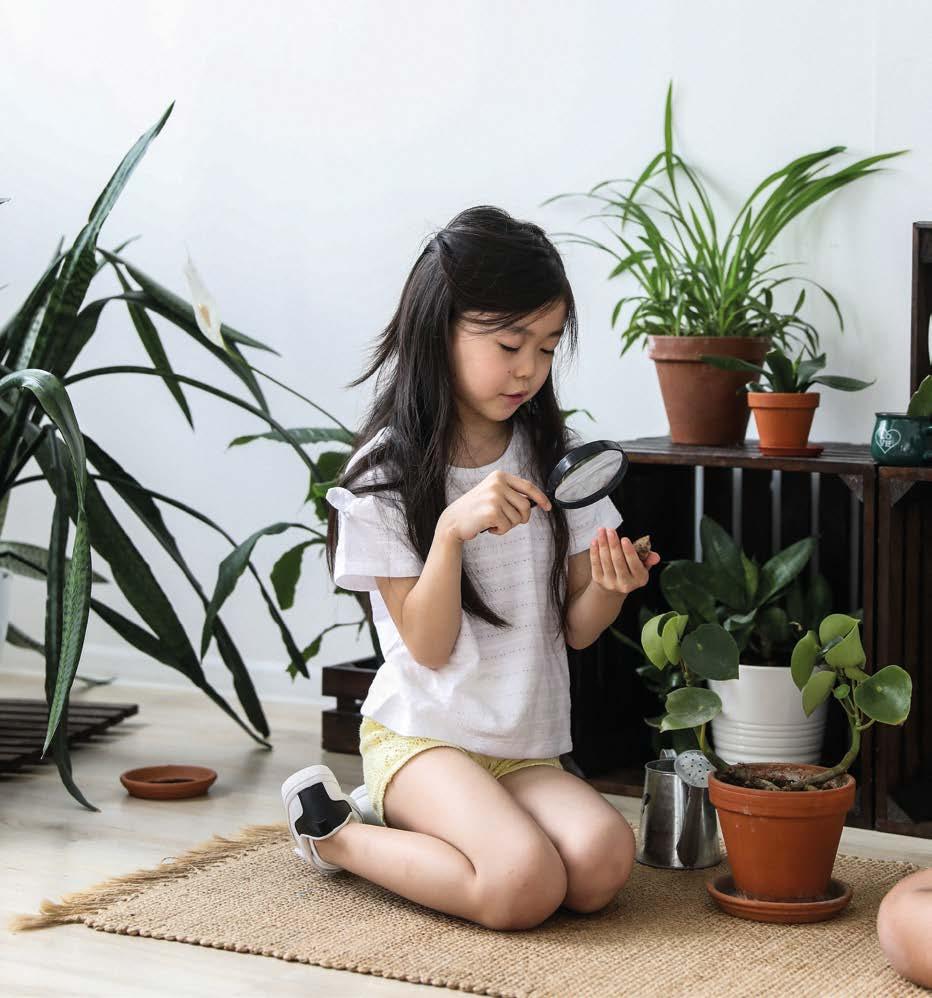 Fille observant une plante à la loupe